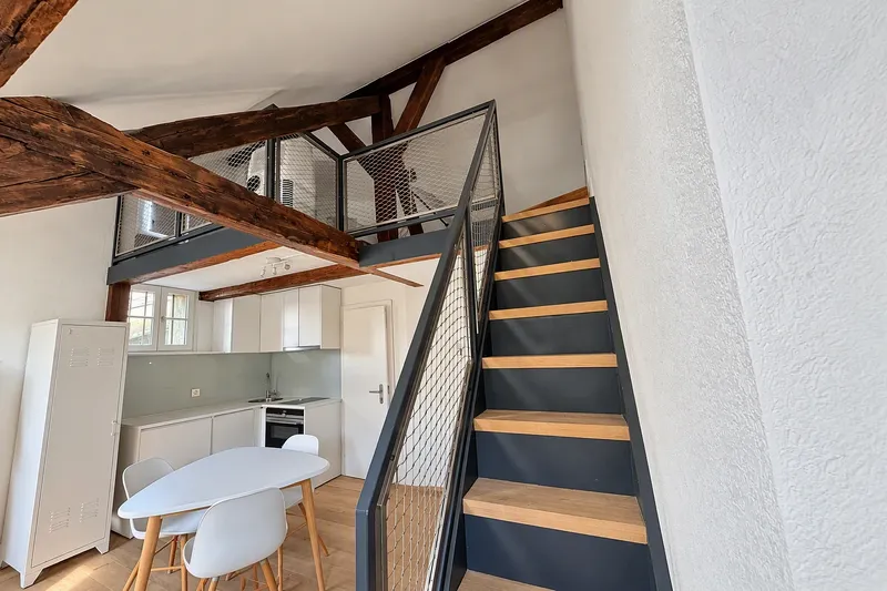 Pièce principale avec cuisine et escalier vers la mezzanine